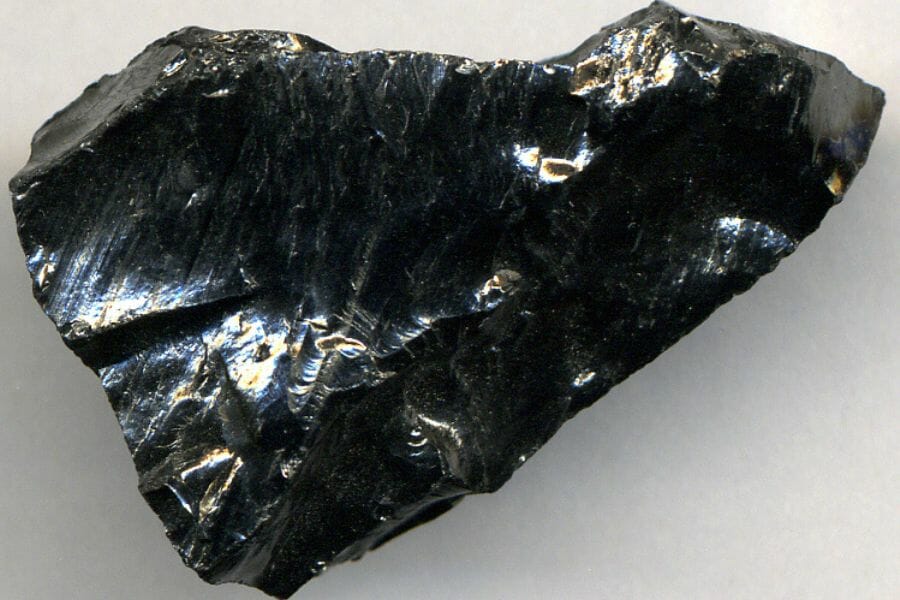 A huge, shiny Black Anthracite on a gray surface