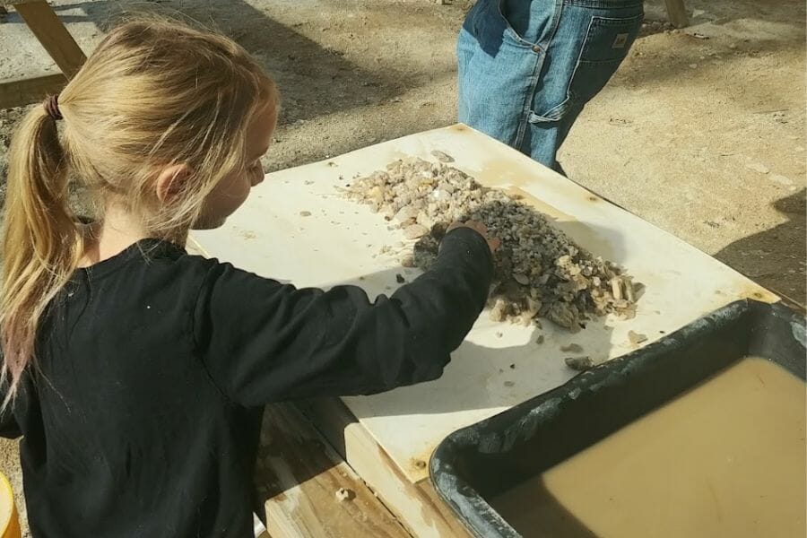 A girl looking for gems at Dig Maine Gems