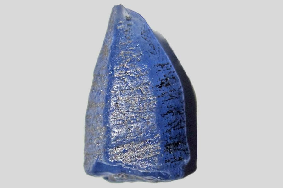 A beautiful blue Sapphire against a light gray background