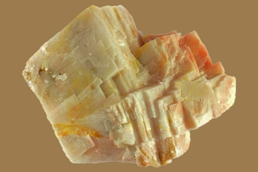 An apricot-colored Calcite against a light brown background