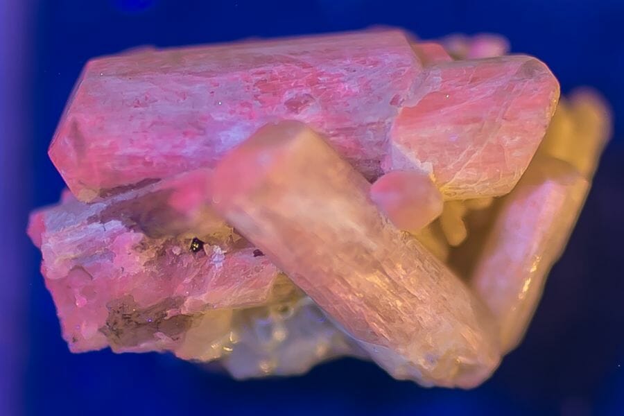 A pinkish white Scapolite against a blue background