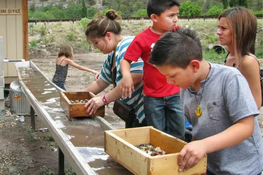 Two children just about to sift through their mine roughs at the sluice of Fox Cave & Gem Mine