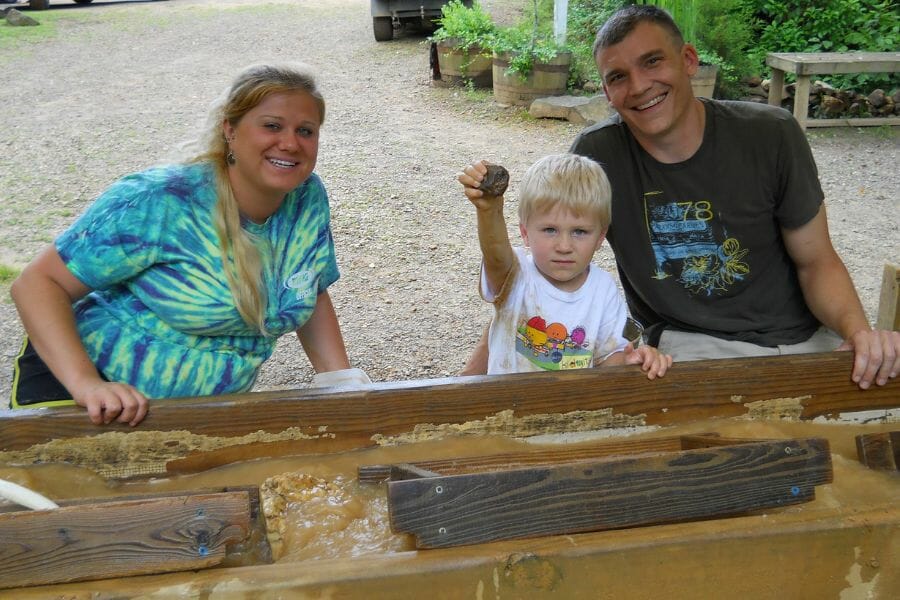 A kid proudly shows the gemstone he found at the Rose Creek Gem Mine