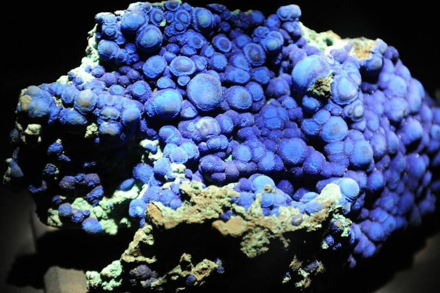 An amply lit violet blue Azurite attached to a big rock