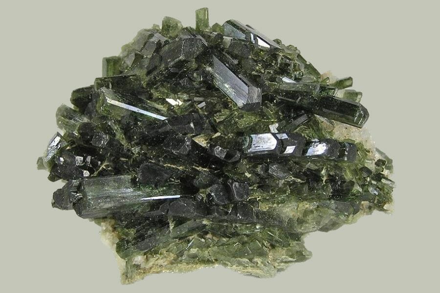 A beautiful and shiny green Diopside against a light green background