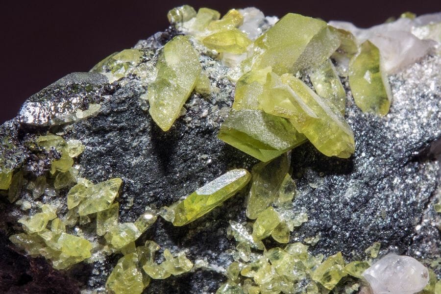 Pieces of yellow green Sphene attached to a rock