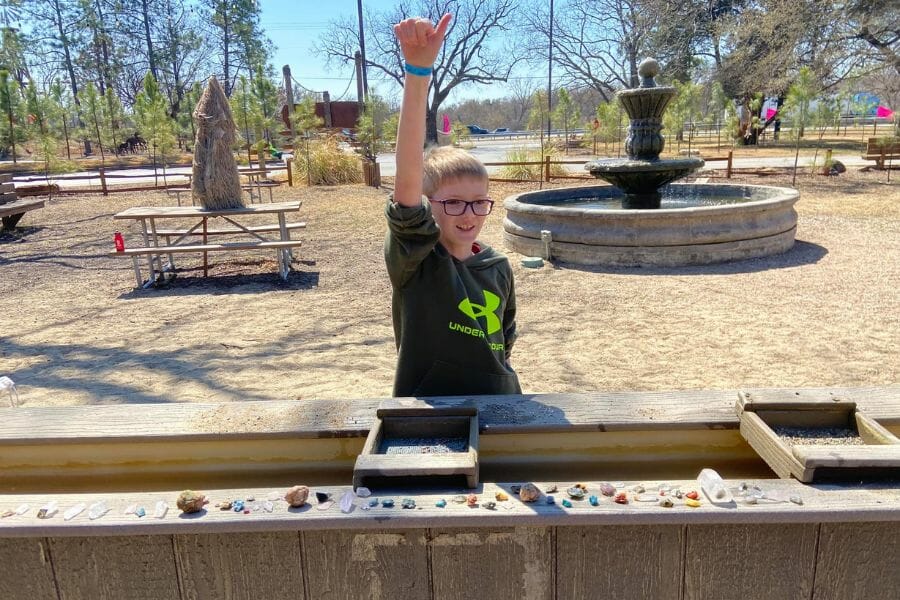 A kid raised his thumbs up as he finished sluicing gemstones at the North Texas Jellystone Park