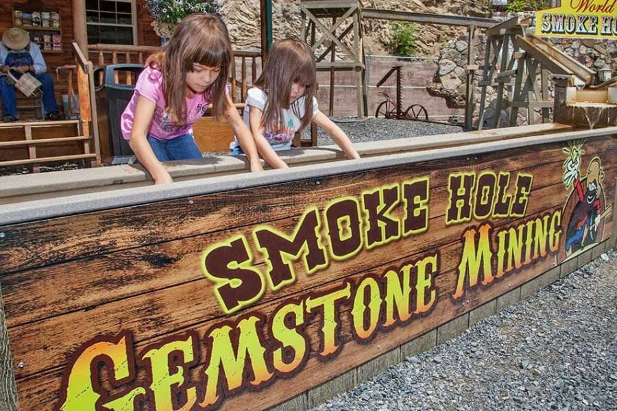 Two girls sifting for gems at the mine sluice of Smoke Hole Gemstone Mining