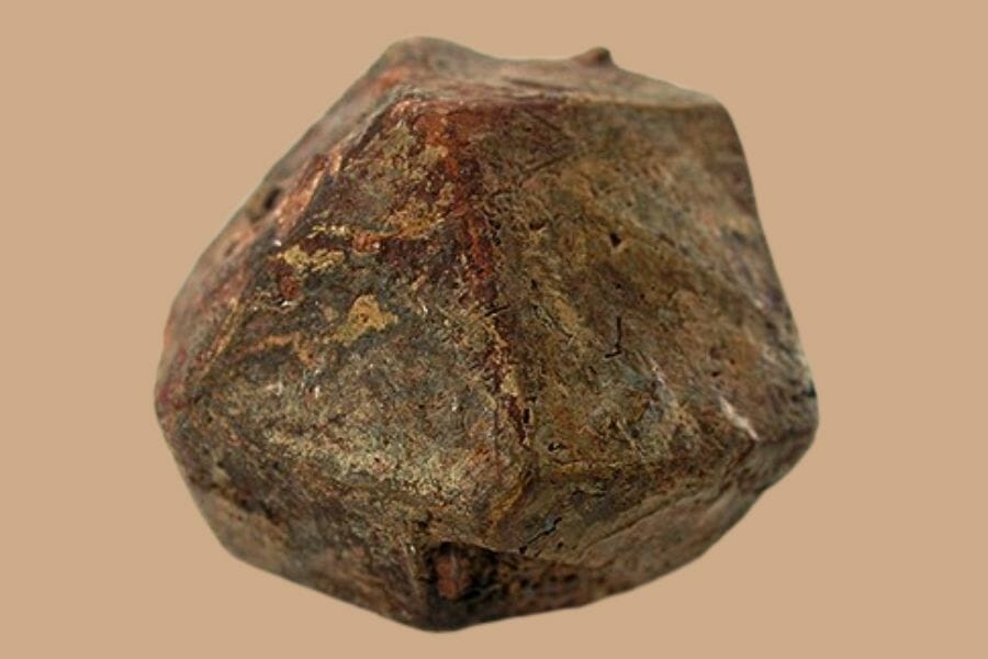 A round, brown Betafite with a mix of different hues in closeup