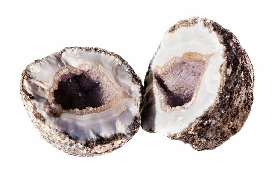 A beautiful chalcedony geode cracked open with purple crystals inside
