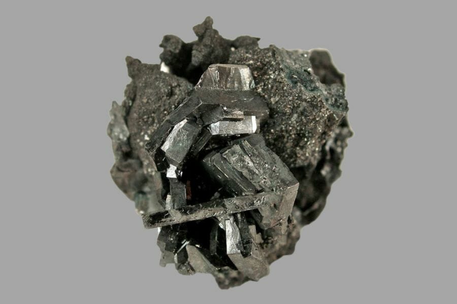 An intricate sample of a gray Stephanite with a light gray background