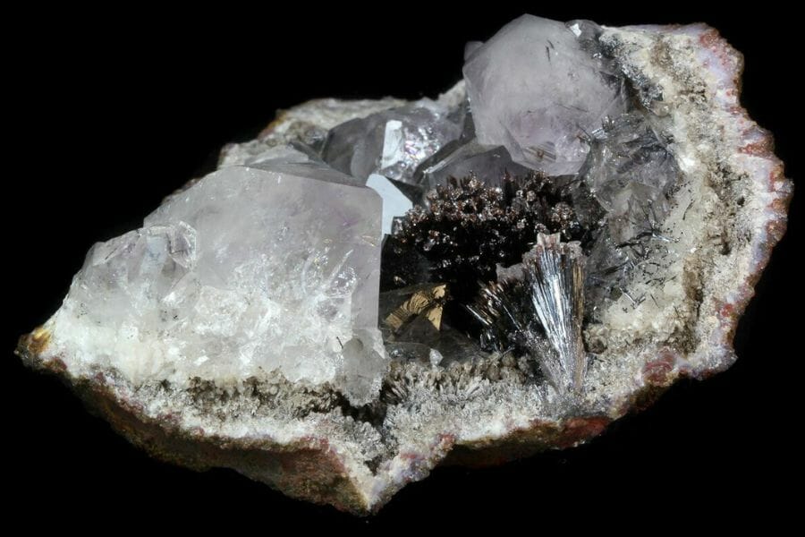 Pyrolusite and Quartz crystals in a cracked open geode