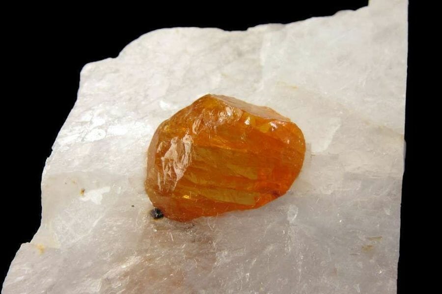 A close look at an uncut orange Norbergite still attached to a crystal