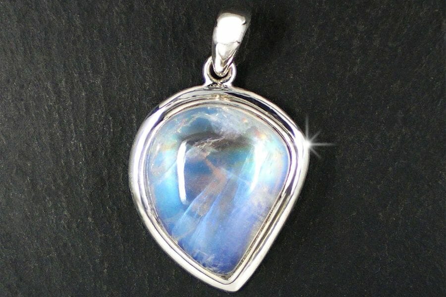 A mesmerizing white Moonstone reflecting colors of blue and purple on a pendant