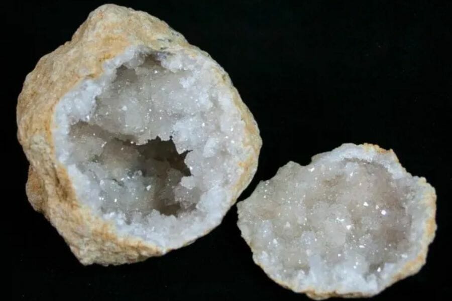 Two sides of a geode showing white, shiny crystals inside