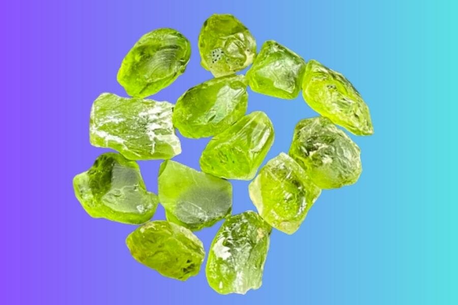 A bunch of shining, light green Peridot crystals on violet and blue background