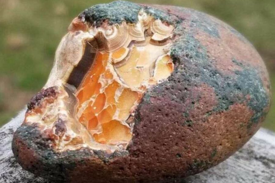 A beautiful semi-cracked agate geode sitting on a rock
