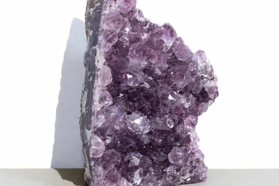 A pretty amethyst crystal standing on the ground