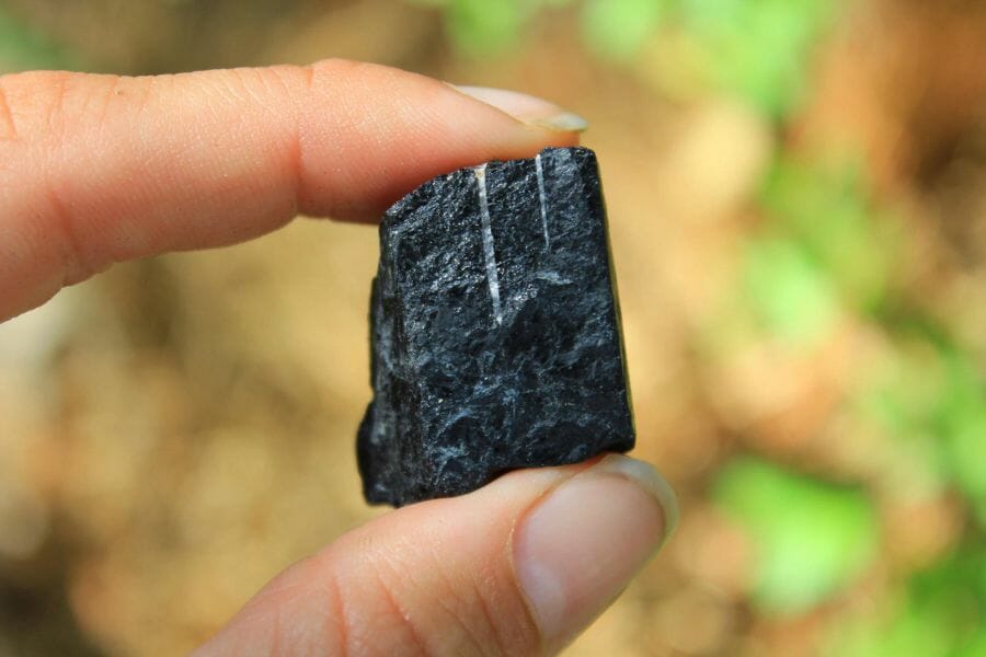 A tiny black tourmaline with white streaks