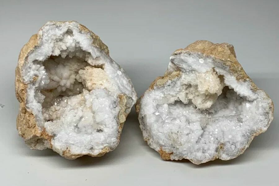 Two open geodes with white and off-white crystals