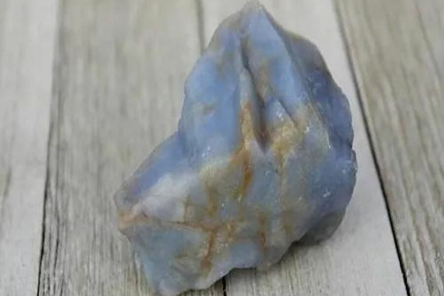 A pretty chalcedony sitting on a wooden surface
