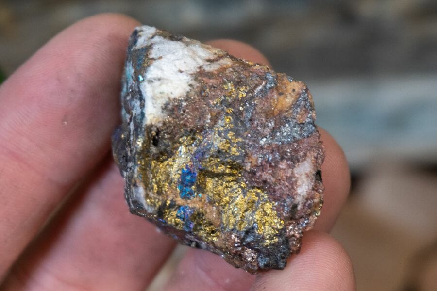 A tiny chalcopyrite with blue hues and gold streaks