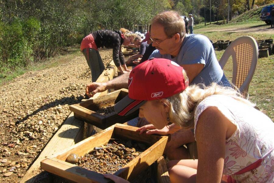 A line of people at a sorting trough at Cherokee Ruby and Sapphire Mine