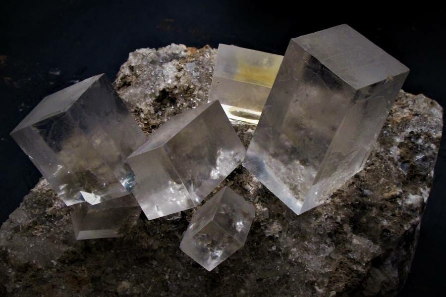 rough square clear crystals protruding from a rock