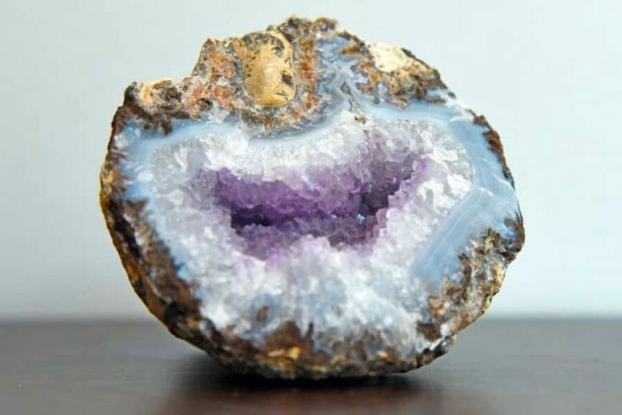 A sample of an open geode lined with blue, white, and purple crystals