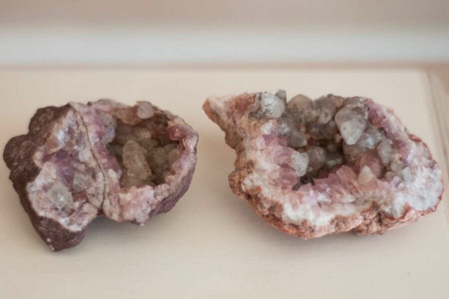 Two opened geodes showing pinkish-white crystals