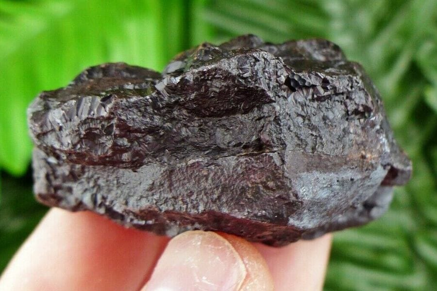 A solid black hematite with an irregular shape and an uneven surface