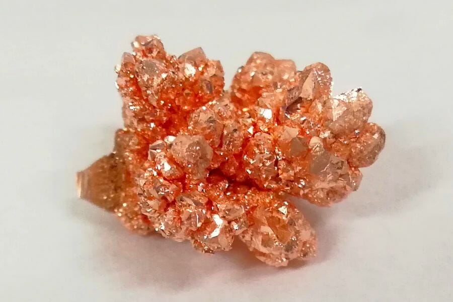 A close up look at a shiny, orange Copper crystal