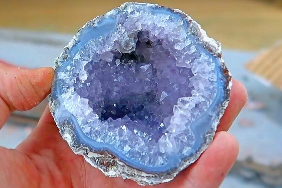 A beautiful sample of an open geode showing blue, white, and purple crystals inside