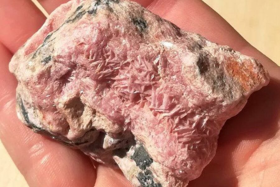 A pretty pink rhodochrosite with black and brown spots