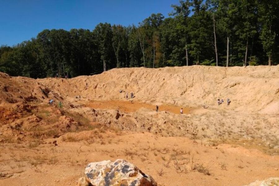 A wide view of the Diamond Hill Mine with a handful of people digging