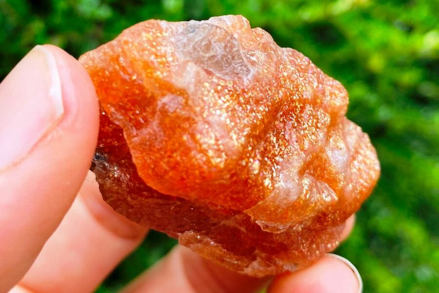 A dazzling orange sunstone with a unique surface and irregular shape