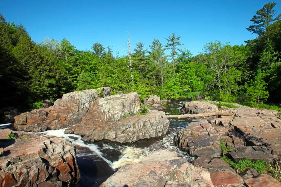 A scenic view of The Bend Deposit showing its rock formations, trees, and water ways