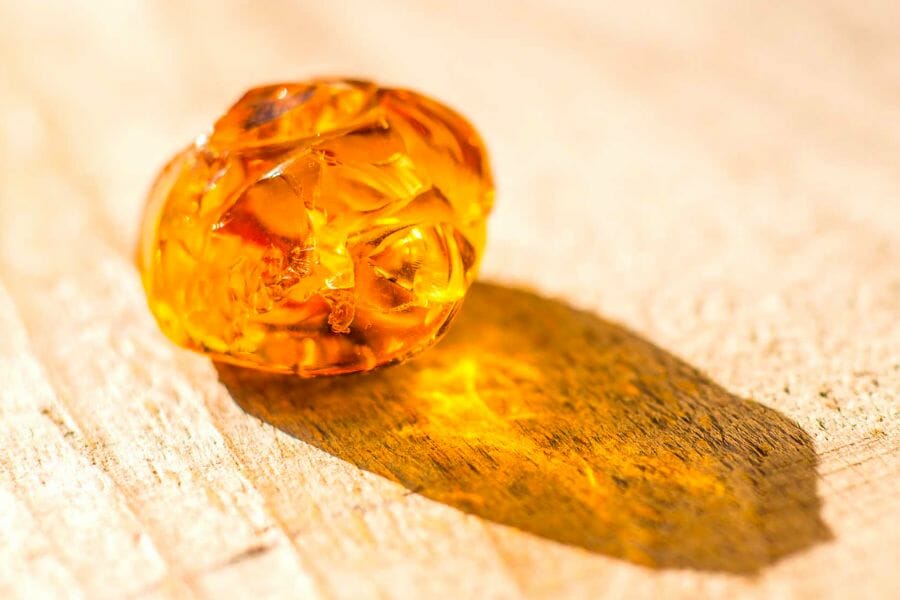 A shiny, translucent yellow Amber with its shadow casting
