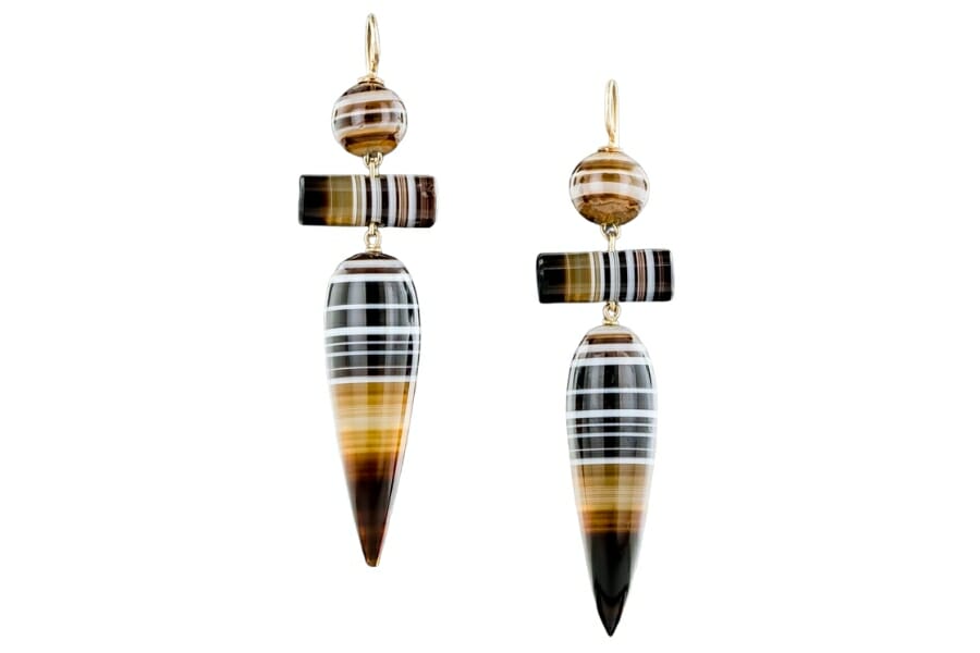 A pair of drop earrings made out of black, brown, and white-patterned Banded Agate