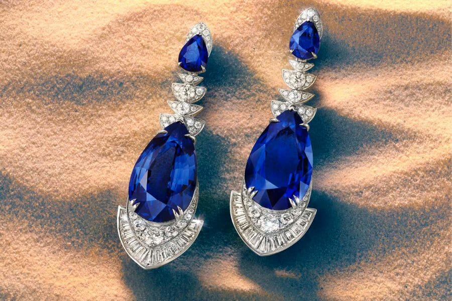 A pair of white gold earrings encrusted with white diamonds and huge pieces of sparkling Blue Sapphire
