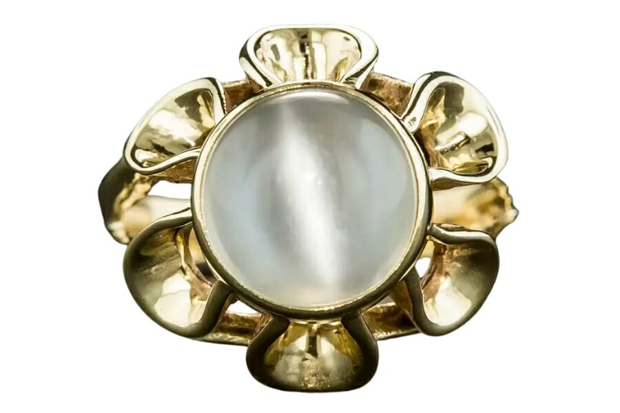 A floral-shaped gold ring with a round Cat's Eye Moonstone set as center stone