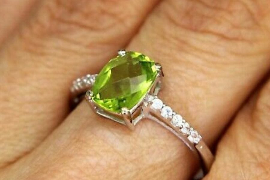 An astonishing peridot ring on a person's finger