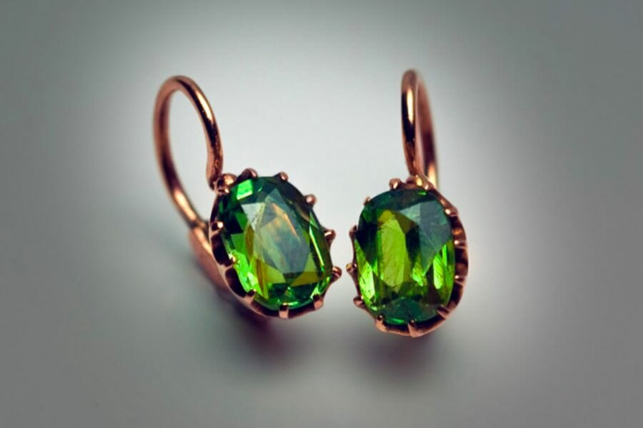A pair of rose gold earrings with rich green Demantoid Garnets