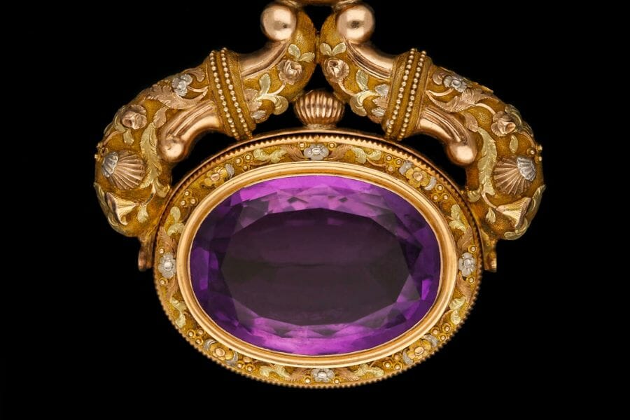 A stunning, deep purple Amethyst attached to a golden pendant