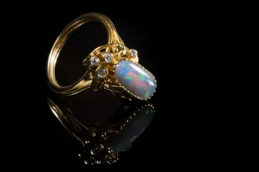 An expensive opal ring with small white crystals and a gold band