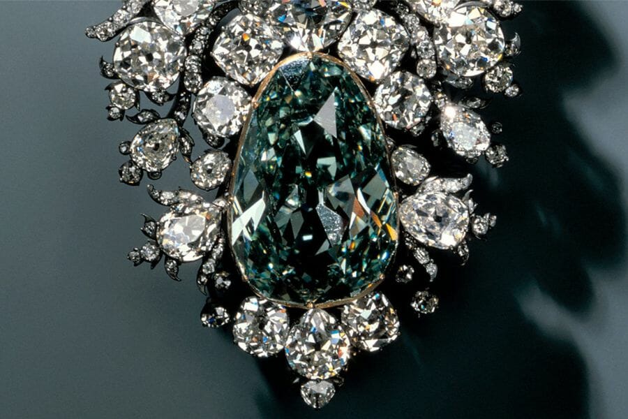A huge green diamond earring surrounded by smaller diamond stones
