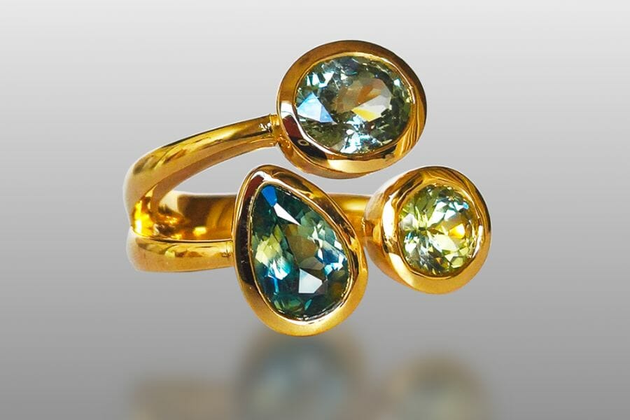 Three sparkling pieces of Green Sapphires in a golden ring