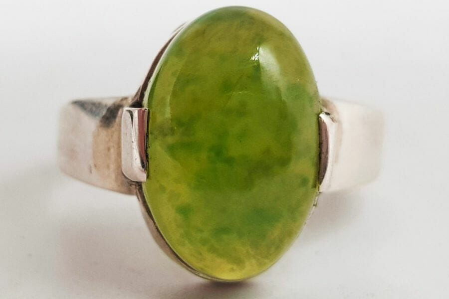 A green gooseberry-looking piece of Grossular Garnet set as a center stone of a ring