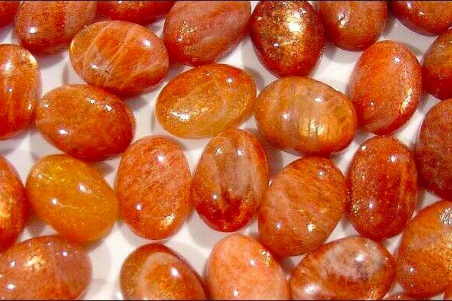 A bunch of shimmering Sunstone crystals in varying intensities of orange hue