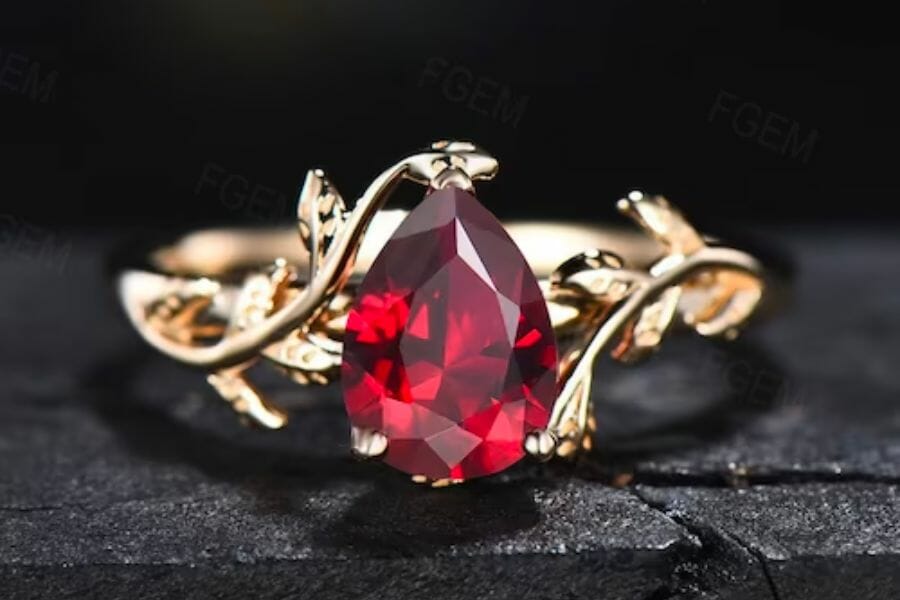 A close up look at a sparkly red Ruby gemstone attached to a gold ring